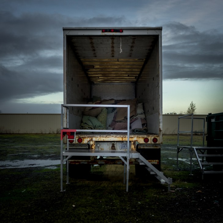 Semi-trailer piled with insulation blankets in parking lot at dawn